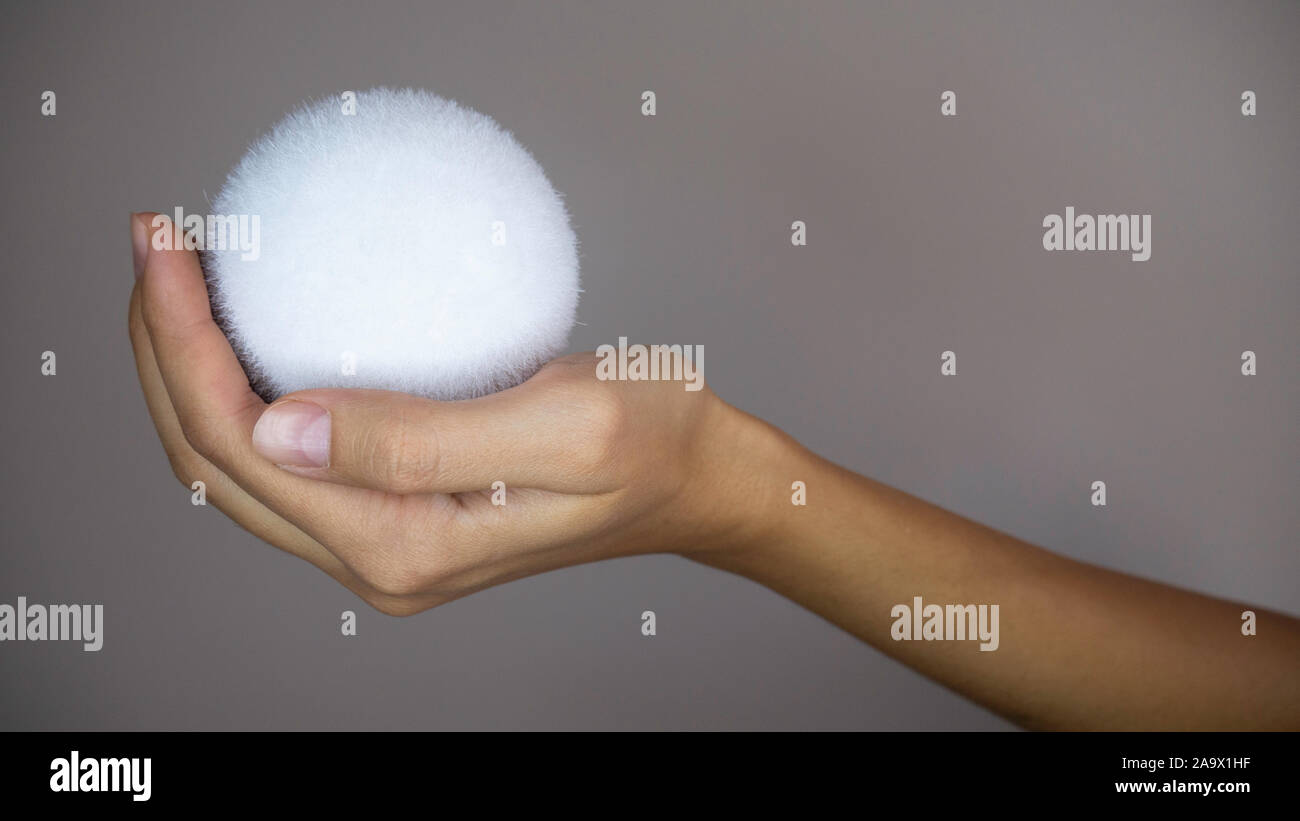 A woman's hand holding a snowball. Banque D'Images