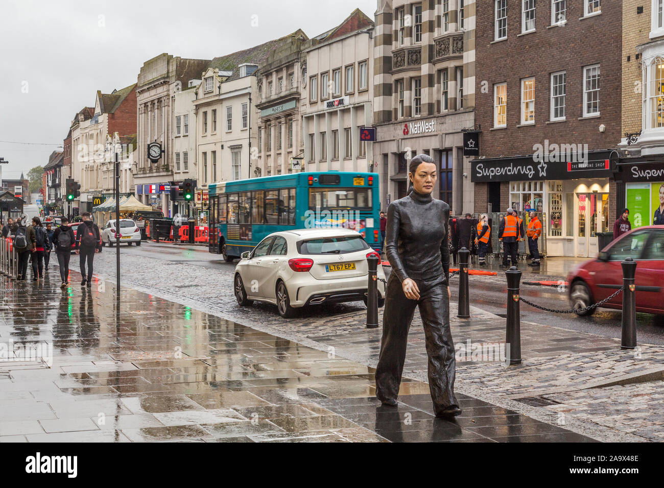 L'accrocheur Walking Woman statue en bronze par le sculpteur Sean Henry marcher à travers Colchester High Street. Banque D'Images
