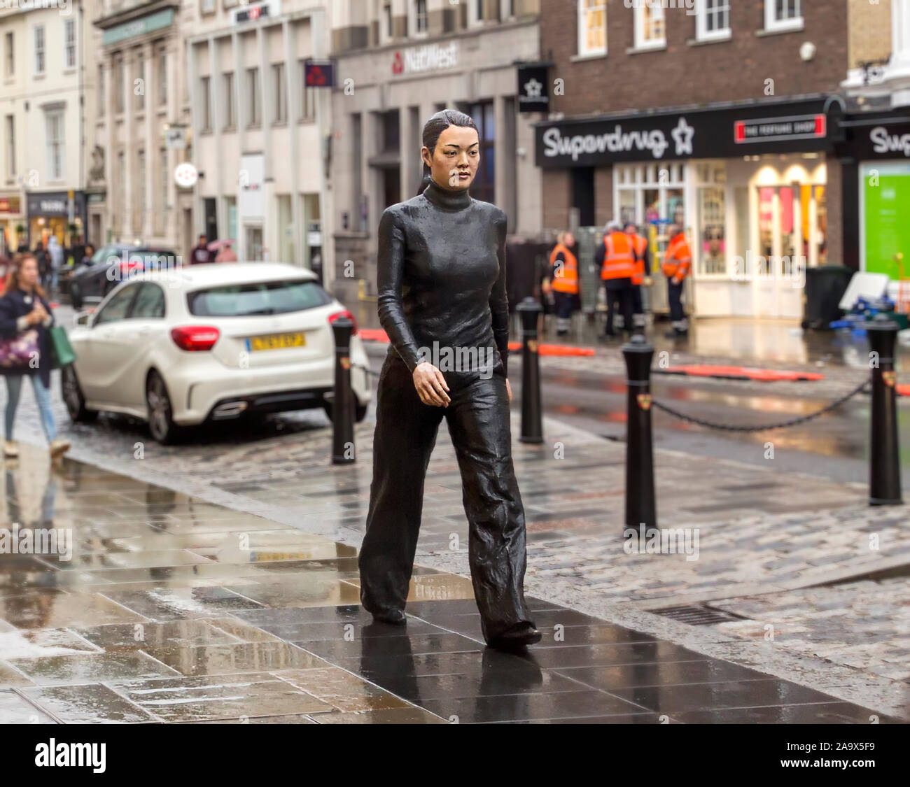 L'accrocheur Walking Woman statue en bronze par le sculpteur Sean Henry marcher à travers Colchester High Street. Banque D'Images