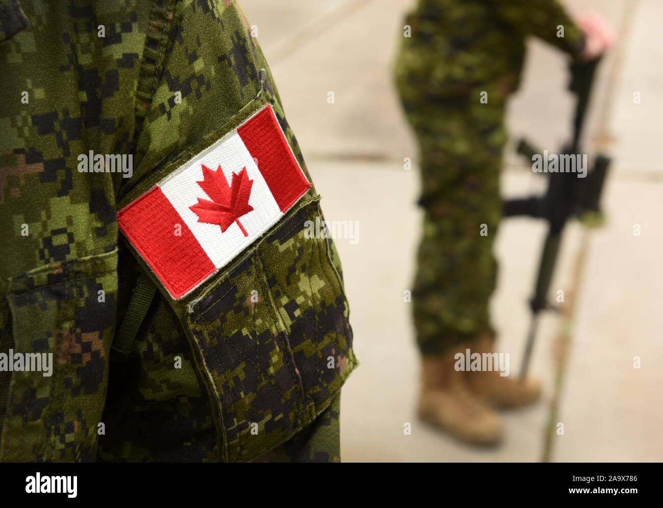 Drapeau du Canada sur l'uniforme militaire et guerrier avec arme sur l'arrière-plan. Les soldats canadiens. L'Armée canadienne. Le Jour du souvenir. La fête du Canada. Banque D'Images