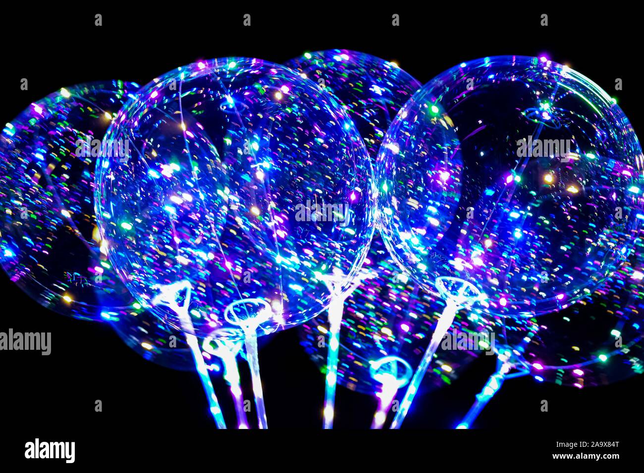 Image flou artistique des lumières des néons allumés ballons remplis d'hellium avec led diods de nuit. Banque D'Images