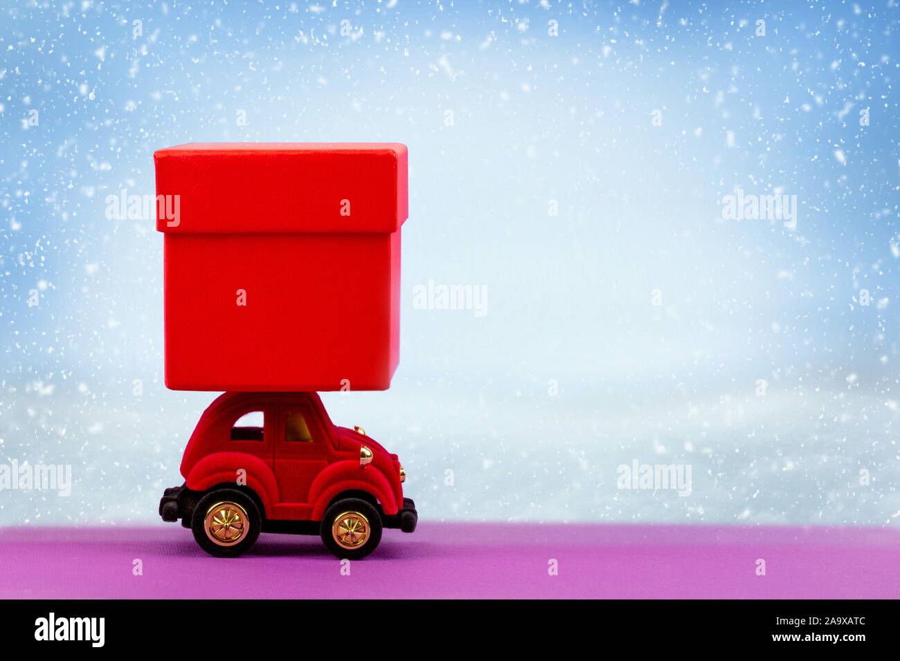 Velours rouge petite voiture rouge avec boîte-cadeau pour Noël, nouvel an, Saint Valentin, anniversaire sur neige de l'hiver fond with copy space Banque D'Images