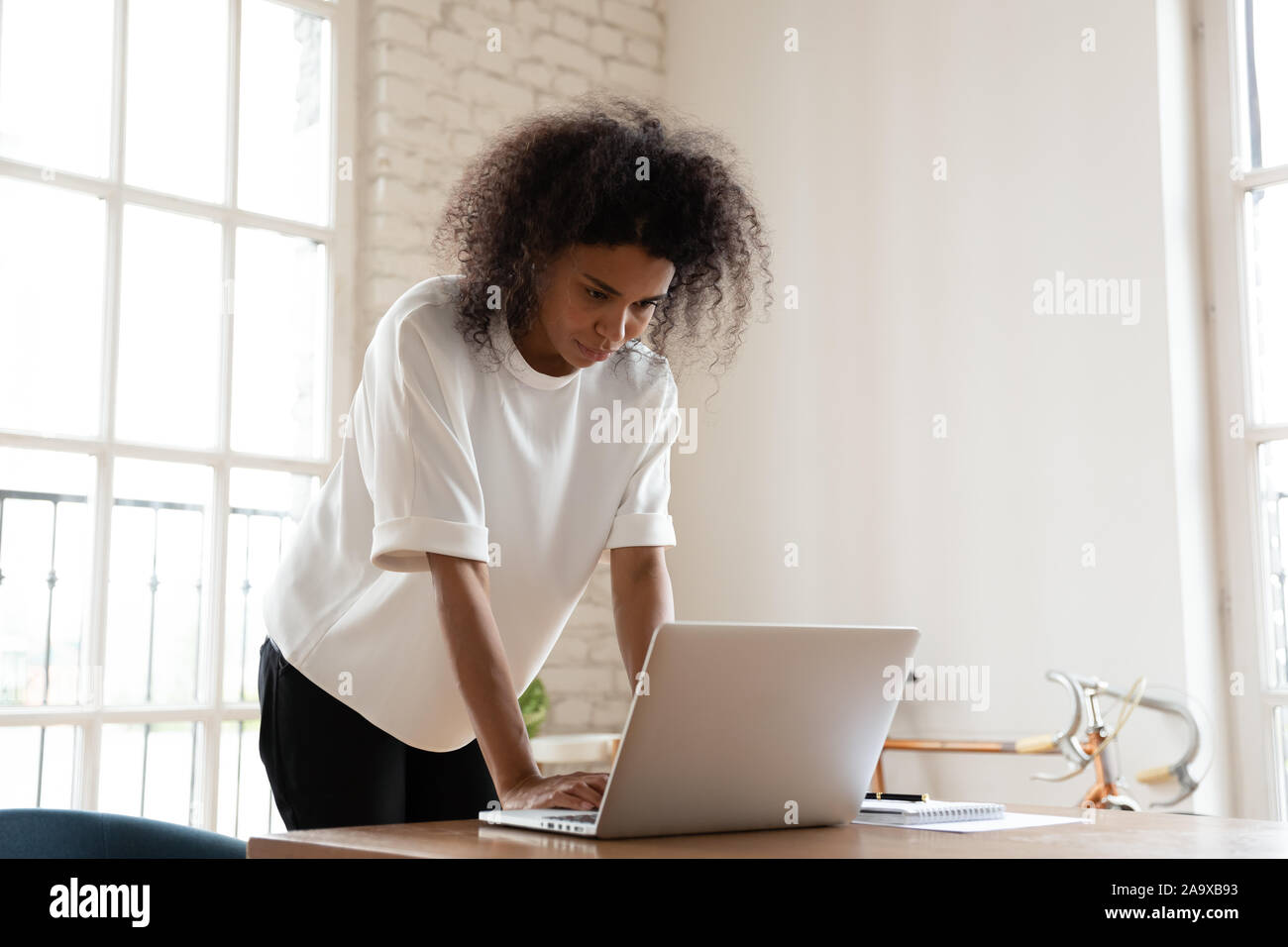 Perplexe young african american employé écrit réponse par courriel. Banque D'Images