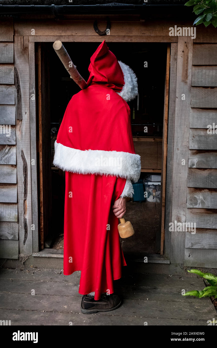 Vue arrière d'un homme portant costume père noël debout dans un atelier de la porte. Banque D'Images