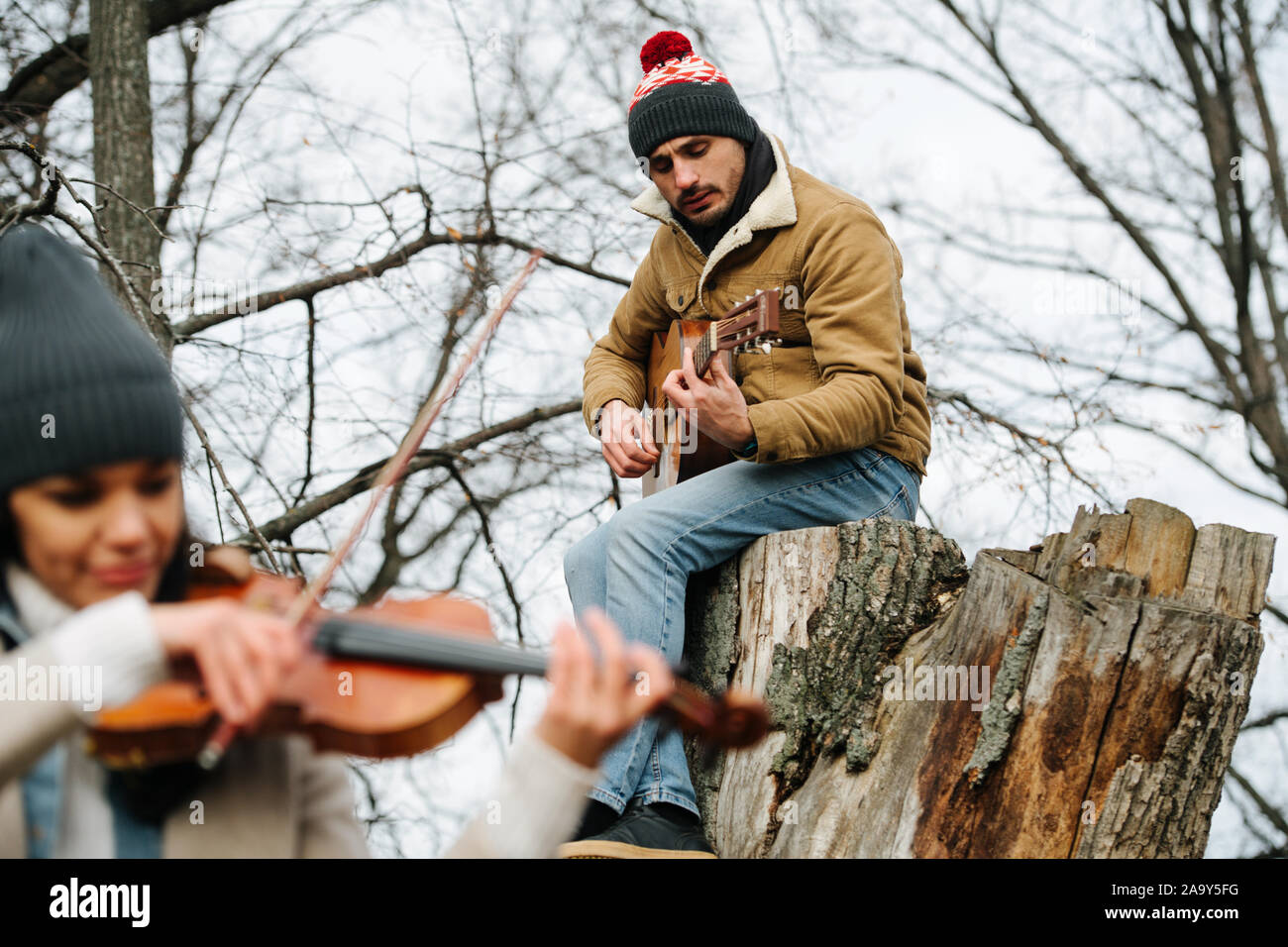 Duo de violoniste et guitariste, jouer de la musique dans une belle forêt d'automne Banque D'Images