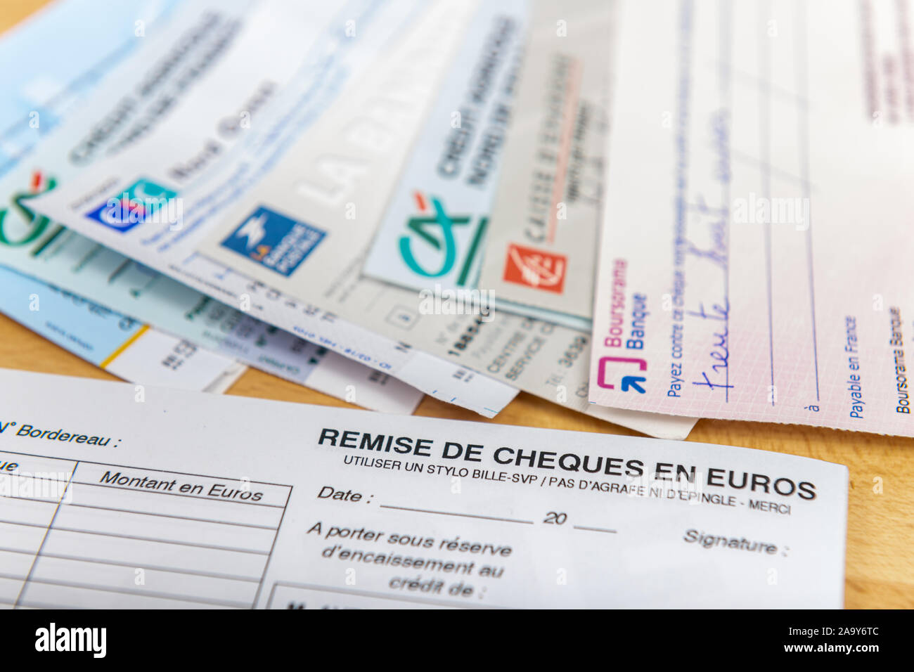 Paris, France - 18 novembre 2019 : vérifie des différentes banques françaises situé sur un bureau en bois. La France est le pays européen où les contrôles sont les plus utilisés Banque D'Images