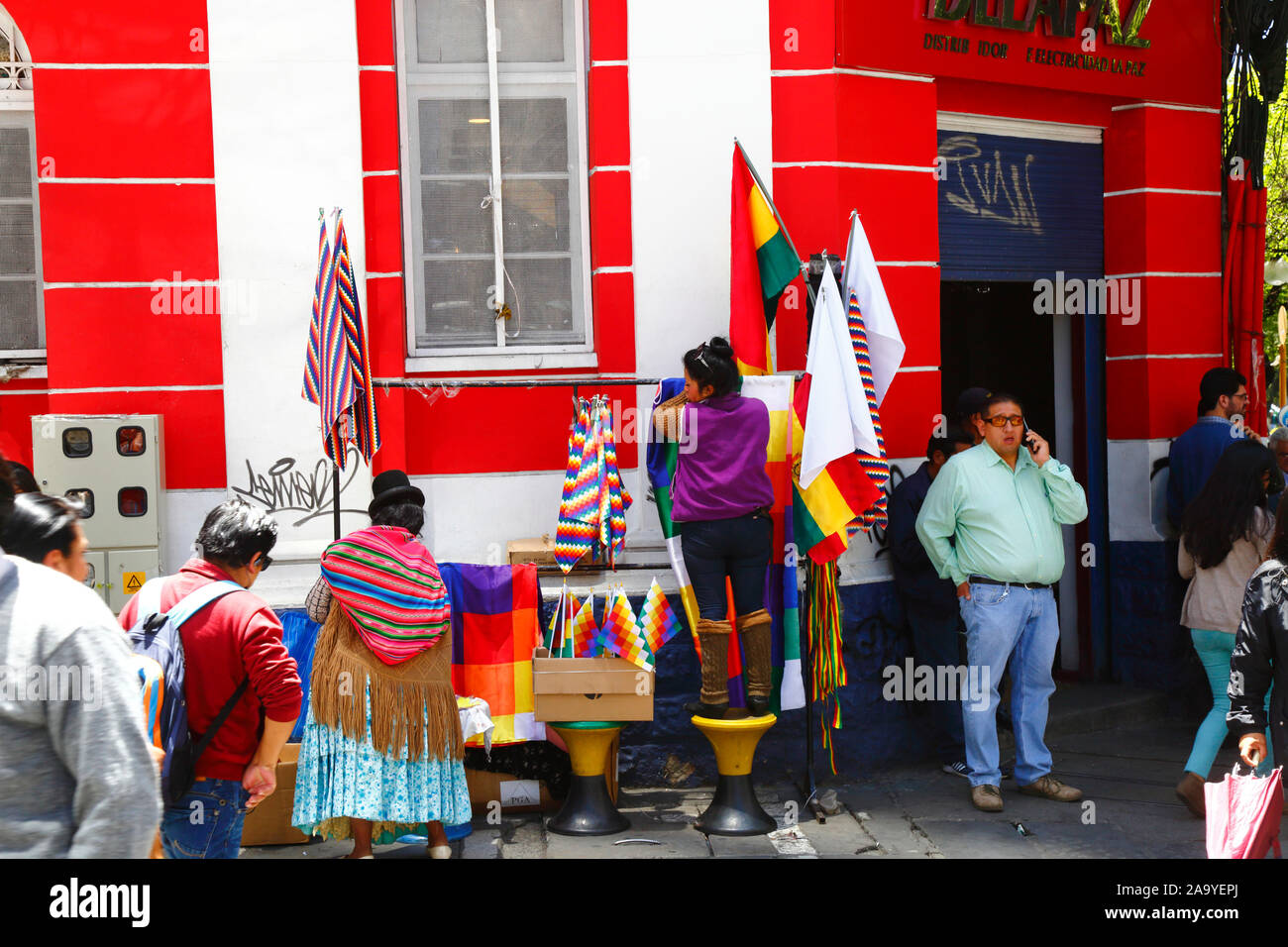 La Paz, Bolivie, 18th octobre 2019. Une femme installe une cabine vendant des drapeaux wipala à un coin de rue à centra la Paz. La Bolivie a tenu des élections présidentielles le 20th octobre, une enquête ultérieure de l'OEA a confirmé un grand nombre d'irrégularités et le président Evo Morales a démissionné le 10th novembre. Au cours des manifestations, quelques drapeaux de wiphala (qui sont un symbole du peuple indigène andin) ont été incendiés, ce qui a conduit à de grandes marches de protestation exigeant que le wiphala soit respecté. Banque D'Images