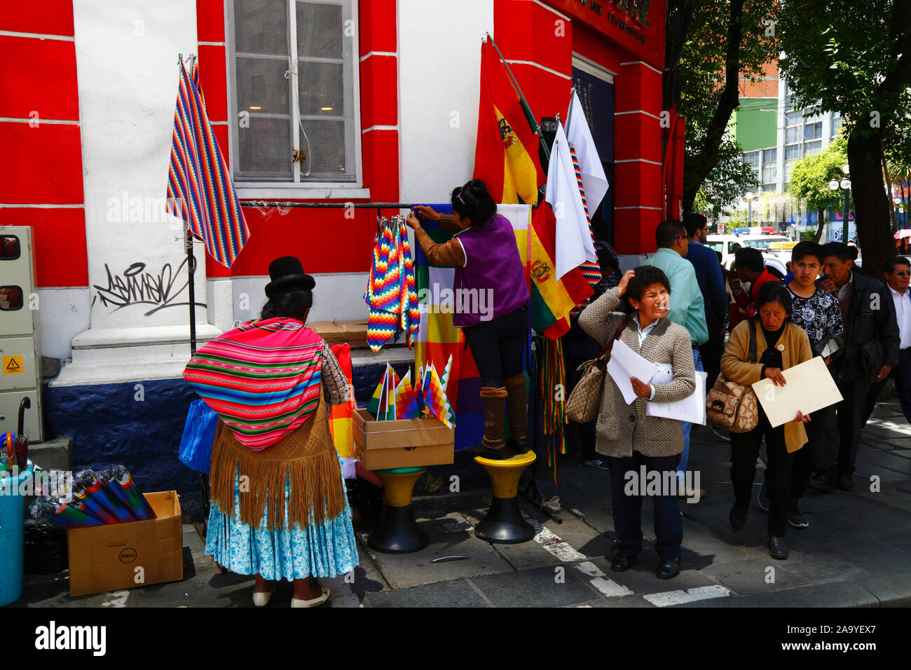 La Paz, Bolivie, 18th octobre 2019. Une femme installe une cabine vendant des drapeaux wipala à un coin de rue à centra la Paz. La Bolivie a tenu des élections présidentielles le 20th octobre, une enquête ultérieure de l'OEA a confirmé un grand nombre d'irrégularités et le président Evo Morales a démissionné le 10th novembre. Au cours des manifestations, quelques drapeaux de wiphala (qui sont un symbole du peuple indigène andin) ont été incendiés, ce qui a conduit à de grandes marches de protestation exigeant que le wiphala soit respecté. Banque D'Images