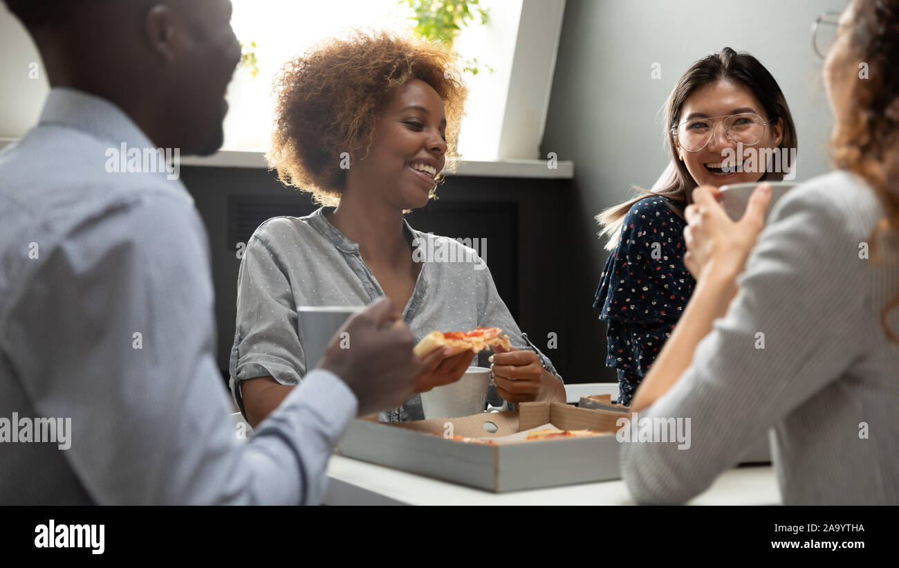 Mixed Race collègues bénéficiant d''un déjeuner partage sur le lieu de travail. Banque D'Images