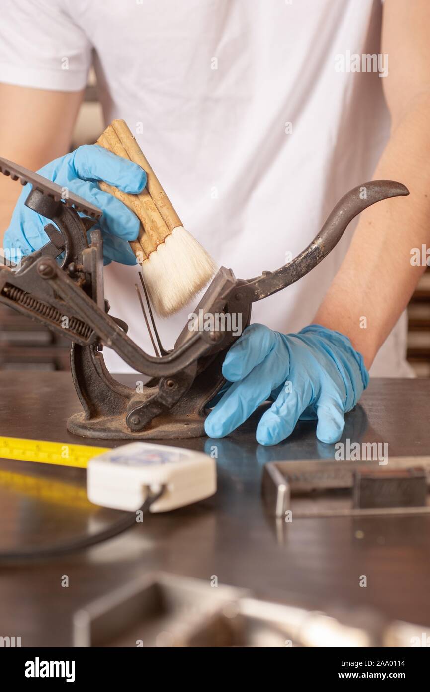 Un restaurateur du musée, le port des gants, utilise un pinceau pour nettoyer un objet en métal, 2 février 2009. À partir de la collection photographique de Homewood. () Banque D'Images