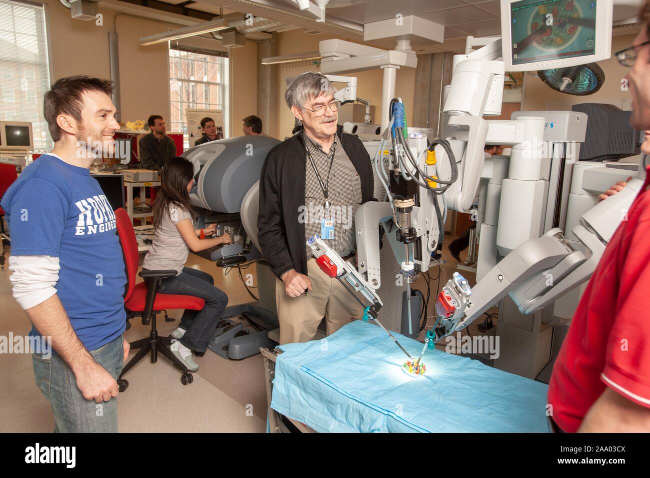 Professeur d'informatique, Russell Taylor, discute avec des étudiants en génie de l'École de merlan tandis qu'un robot chirurgical da Vinci travaille dans une fausse salle d'opération à la Johns Hopkins University, Baltimore, Maryland, le 6 avril 2009. À partir de la collection photographique de Homewood. () Banque D'Images