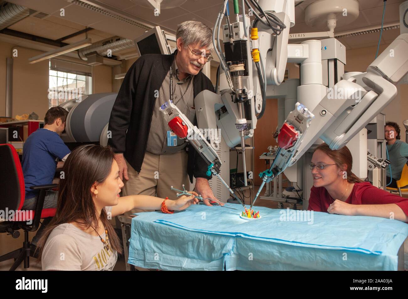 Low angle view of Russell Taylor, professeur d'informatique, de regarder un Whiting School of Engineering student utiliser un long outil pour aider un robot chirurgical da Vinci dans une simulation d'opération à l'Université Johns Hopkins, Baltimore, Maryland, le 6 avril 2009. À partir de la collection photographique de Homewood. () Banque D'Images