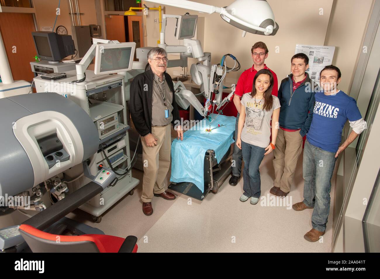 Long Shot du professeur Russell Taylor, debout avec quatre, souriant, Whiting School d'étudiants en génie, et d'un robot chirurgical da Vinci, dans une fausse salle d'opération à la Johns Hopkins University, Baltimore, Maryland, le 6 avril 2009. À partir de la collection photographique de Homewood. () Banque D'Images