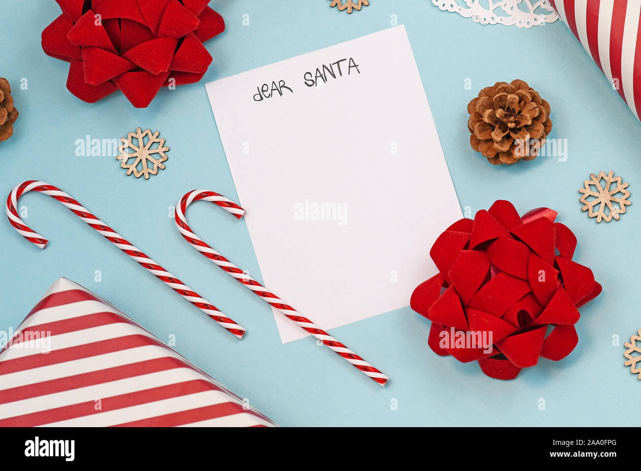 Vacances de Noël la saison de mise à plat avec un concept pour les enfants lettre au Père Noël avec lettre blanc vide, des cannes de bonbon, boîte-cadeau et les rubans sur bleu Banque D'Images