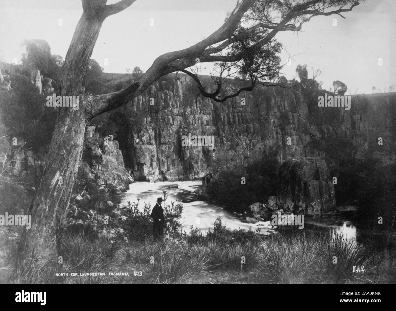 Photographie en noir et blanc d'un homme dans un chapeau debout sur la rive de la rivière North Esk près de Launceston, Tasmanie, Australie, par le photographe Frank Coxhead, 1885. À partir de la Bibliothèque publique de New York. () Banque D'Images
