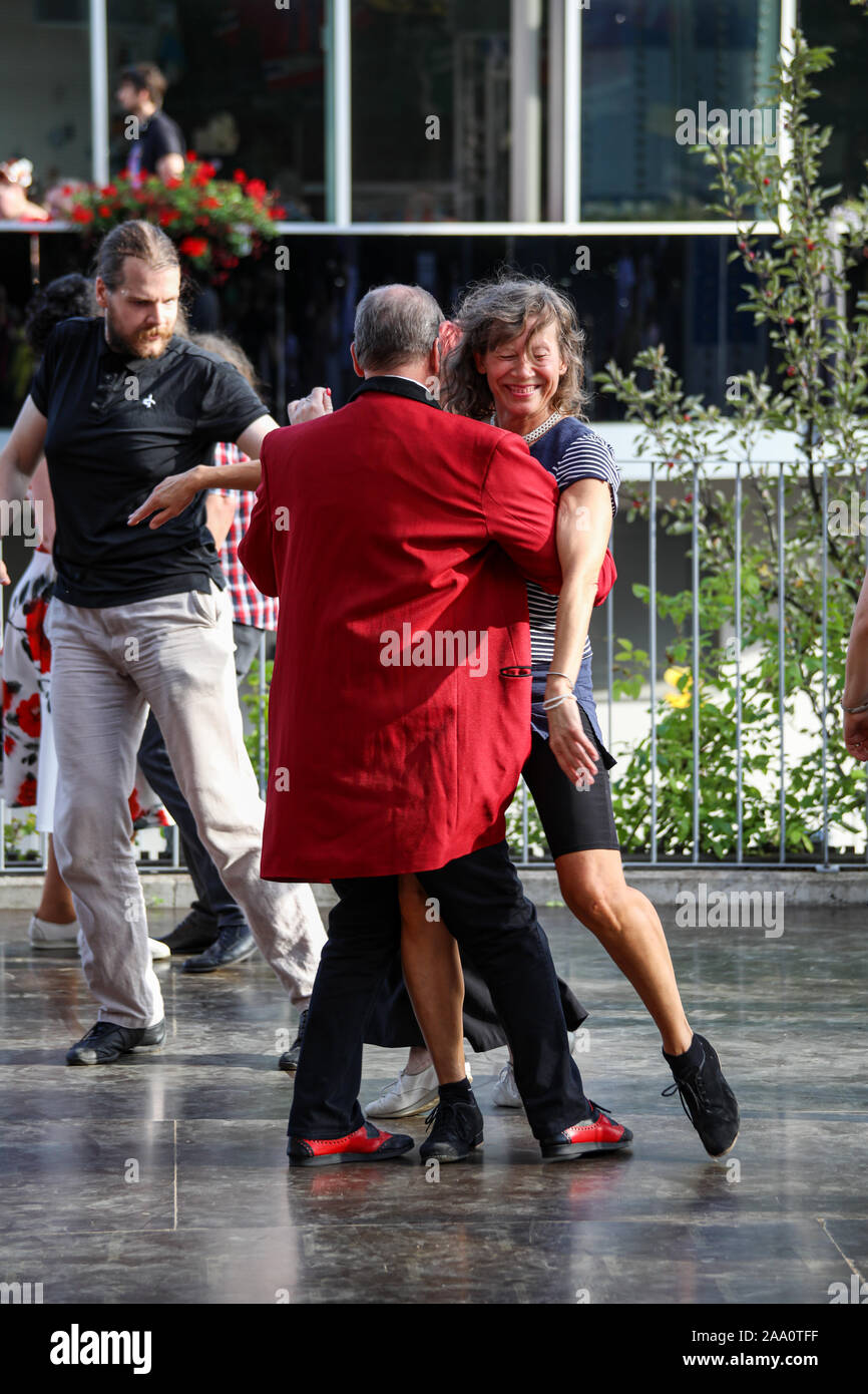 Man in red teddy boy drape danse avec la femme aux cheveux gris Banque D'Images