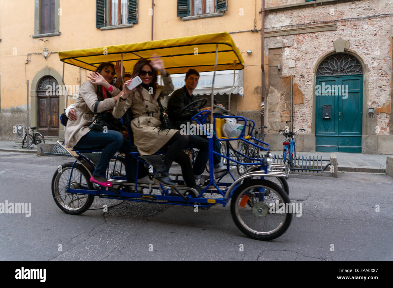 Les touristes avec des téléphones de vague comme ils montent dans le cadre du PISA, Italie à 4 roues pedicab Banque D'Images