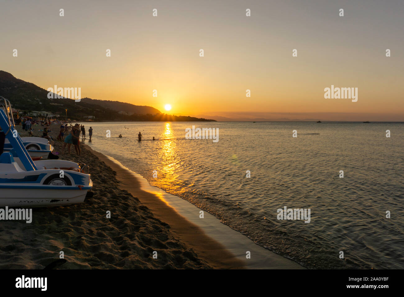 Coucher du soleil à Cefalú, Sicile, des personnes se préparant à quitter la plage comme dusk falls. Banque D'Images