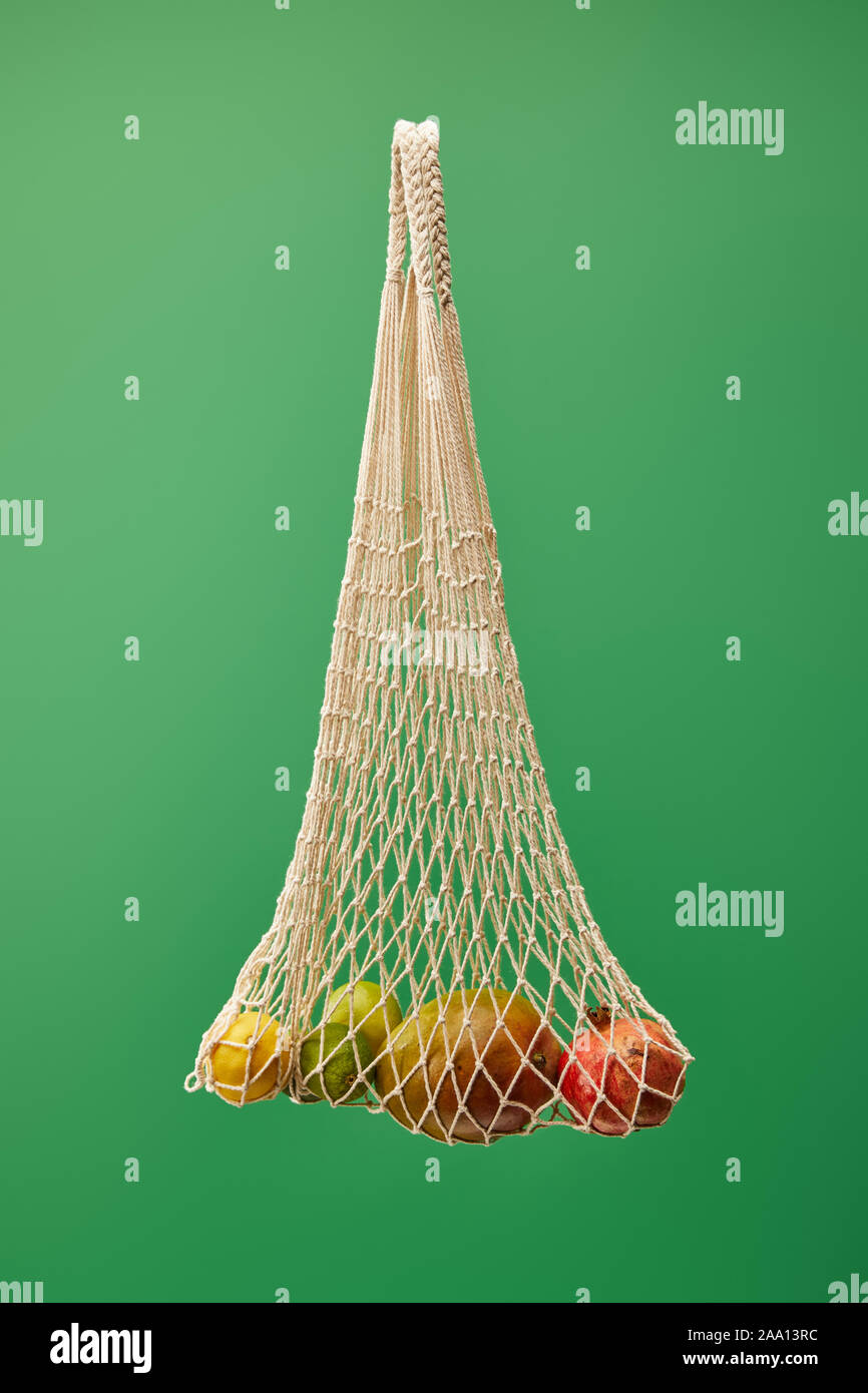 Sac de chaîne avec des fruits isolé sur fond vert Banque D'Images