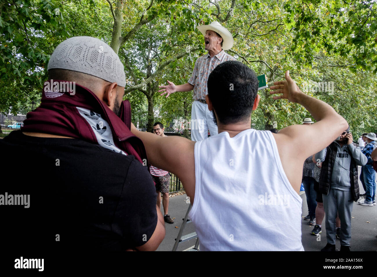 Cuisine américaine, religieux chrétien évangéliste est interrompu par des jeunes musulmans tout en prêchant à Speakers' Corner, Hyde Park, London, UK. Banque D'Images