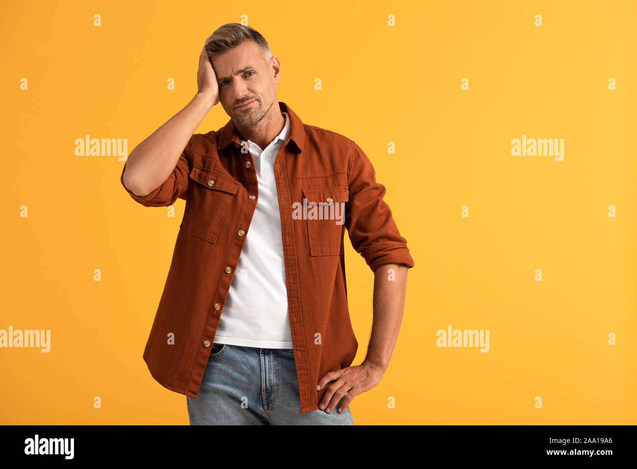 L'homme mécontent de toucher la tête et de permanent isolé sur orange Banque D'Images