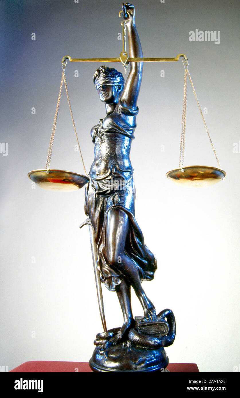 Une statue en bronze de la Justice aveugle détient une paire de balance et une épée. Depuis le