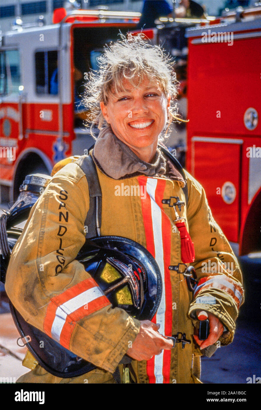 Vetue de son manteau de securite et portant son casque une femme pompier pose a cote de sa plate forme petroliere dans le centre ville de San Diego CA Photo Stock Alamy