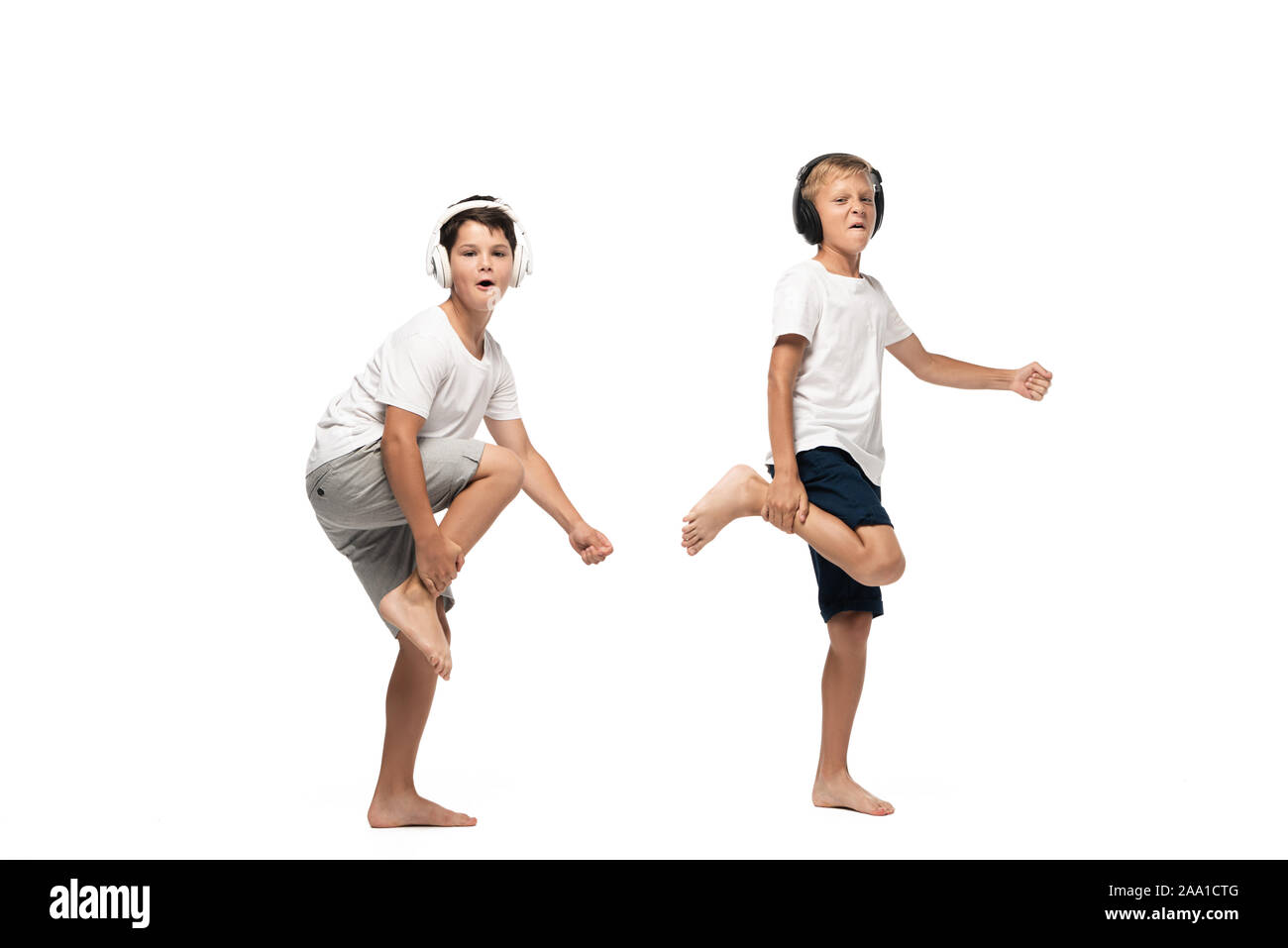 Deux frères enjoué looking at camera et la danse de casque sur fond blanc Banque D'Images