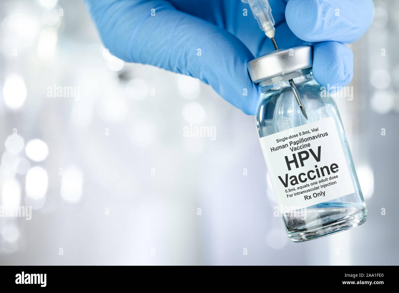 Concept de soins avec une main en bleu gants médicaux holding, HPV Virus du papillome humain, vaccin flacon Banque D'Images