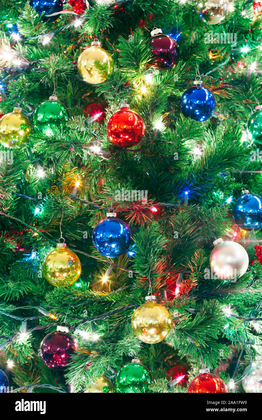 Près d'un arbre de Noël décoré avec des lumières et ornements Banque D'Images