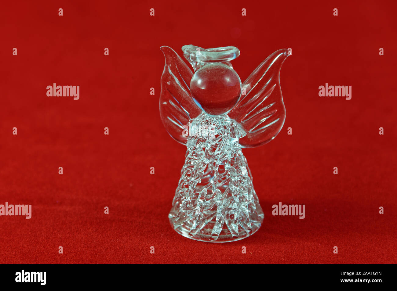 Une belle crysatl ange de Noël, avec un halo, sur un fond rouge Banque D'Images