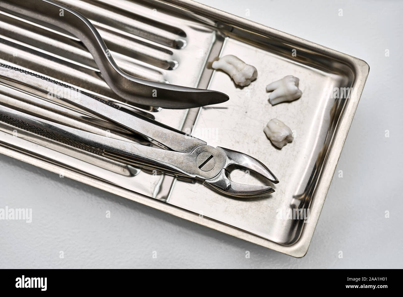 Acier inoxydable Chrome plateau médical avec des instruments dentaires (pinces et un enrouleur de la joue) et trois molaires extraites. Libre photo horizontale. Banque D'Images Acier inoxydable Chrome plateau médical avec des instruments dentaires (pinces et un enrouleur de la joue) et trois molaires extraites. Libre photo horizontale. Banque D'Images