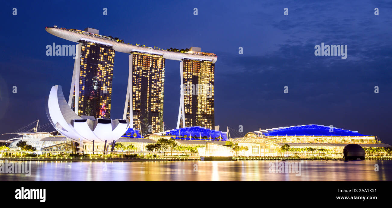 Vue imprenable sur la Marina Bay skyline avec de beaux gratte-ciels illuminés au cours d'un splendide coucher de soleil à Singapour. Banque D'Images