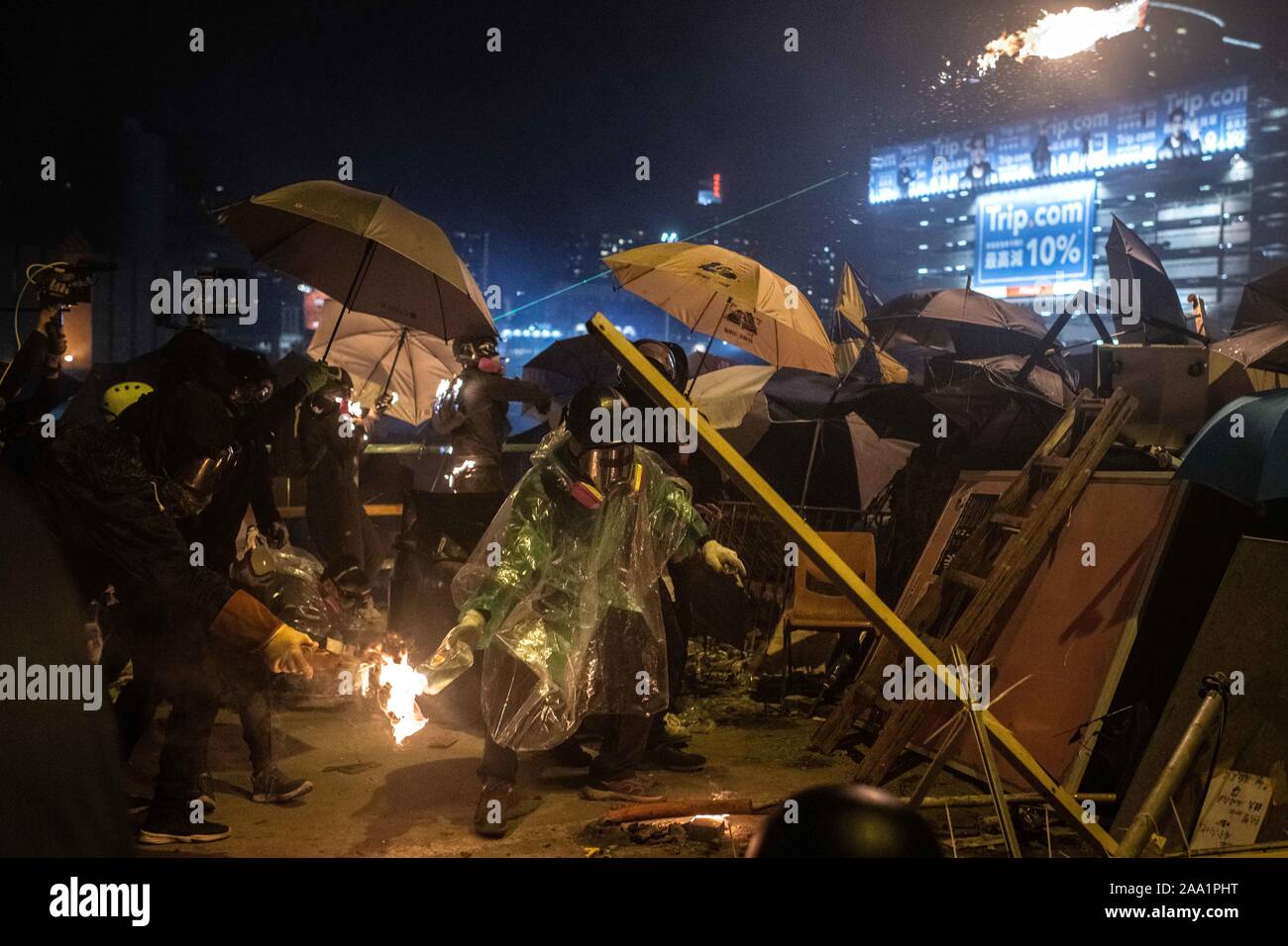 Les manifestants jettent des cocktails Molotov sur la police anti-émeute à l'un des ponts de l'université polytechnique d'accès bloqués par des barricades. Surround de la police de Hong Kong Polytechnic University au cours de la violente d'affrontements. Affrontements entre les manifestants et la police anti-émeute ont continué d'éclater autour de l'Université Polytechnique tout au long de la journée. La police a utilisé des canons à eau, ont tiré des gaz lacrymogènes et des balles en caoutchouc alors que les protestataires ont répondu avec des cocktails molotov et des briques. La plupart des combats concentrés à l'intersection en face de l'entrée principale de l'école. Banque D'Images