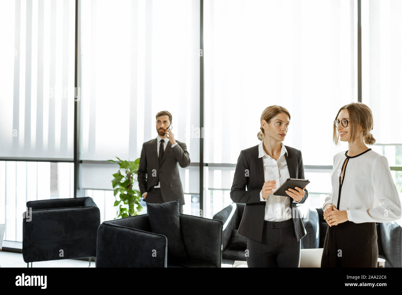 Les employés de l'institution financière ou d'autres grands copany ayant quelques affaires, debout et parler dans le bureau de luxe Banque D'Images