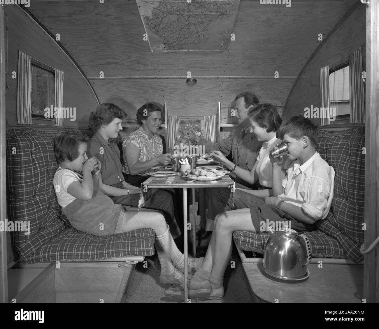 Années 1950 Le camping. Une famille, c'est jouir de leur maison de vacances et de la vie de camping pratiques dans leur caravane. Montrer comment tout fonctionne bien pour eux, même en vacances. La famille de six personnes s'adapte facilement autour de la table. La Suède 1952 Ref 2021 Banque D'Images