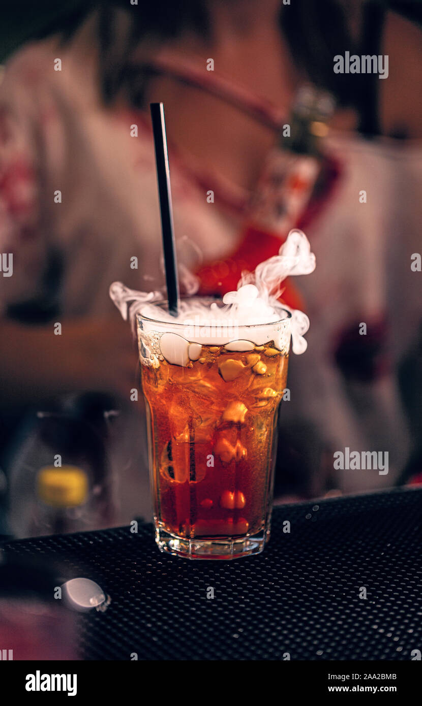Boisson festive Halloween cocktail rouge, avec de la fumée sur le comptoir du bar Banque D'Images