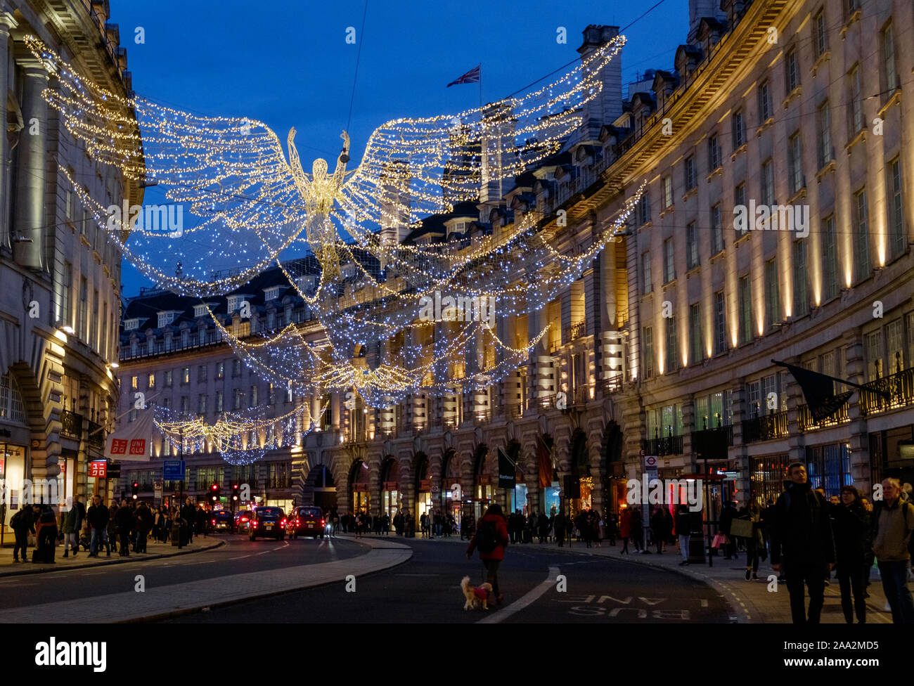 Les lumières de Noël des anges au-dessus de la rue Regent, le centre de Londres, avec des clients de vacances occupé, dans la soirée. Banque D'Images