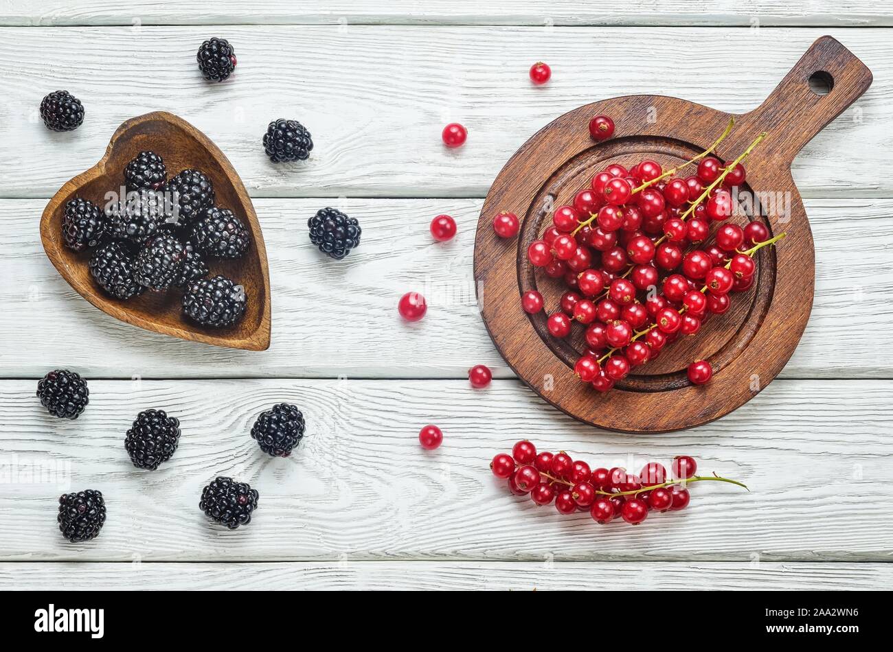 Fruit rouge et noir dans la cuisine. Groseille rouge et blanc blackberry sur une table en bois. Banque D'Images