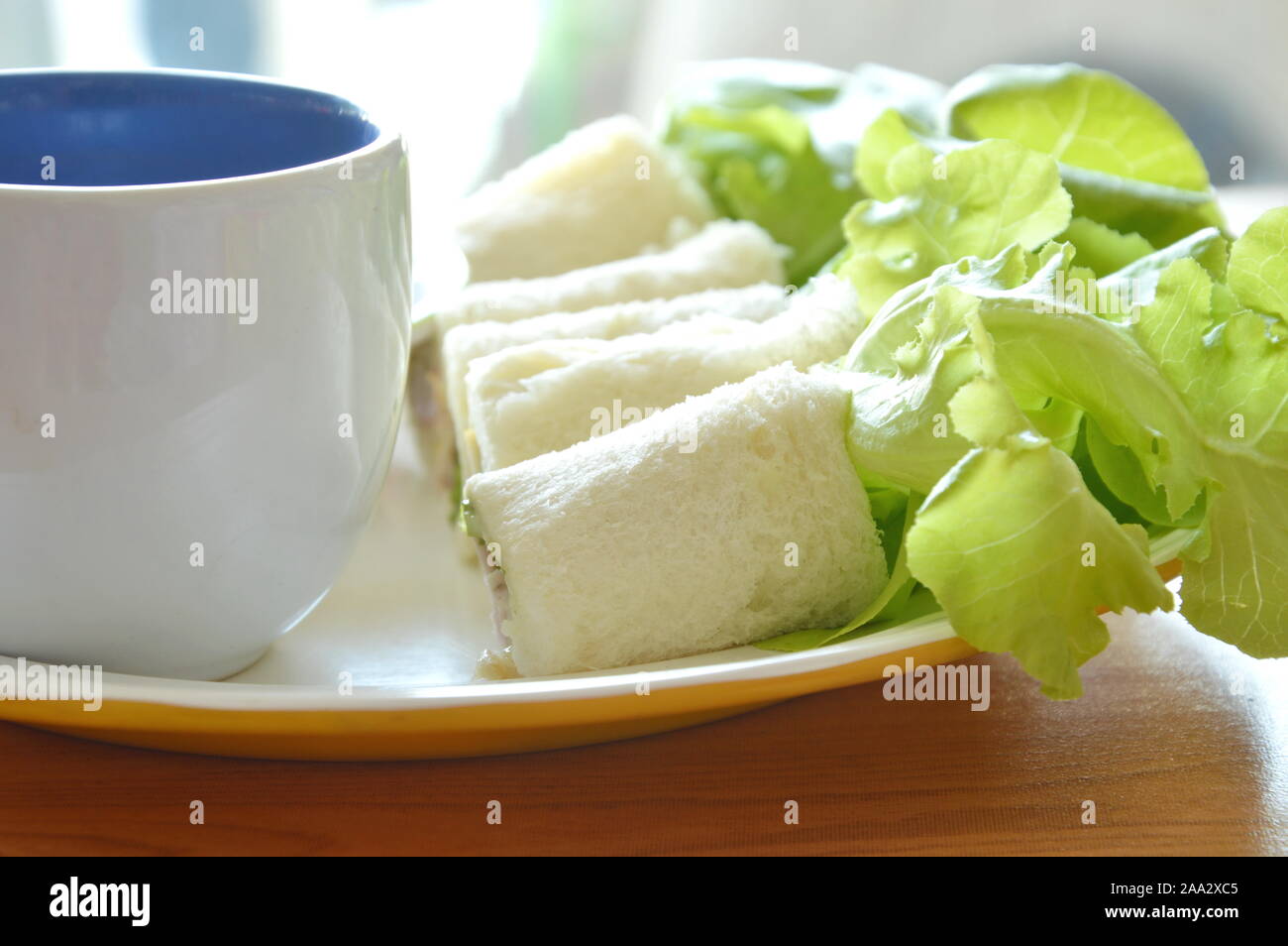 Pain rouleau rempli bologne et chêne vert avec du café sur la plaque Banque D'Images