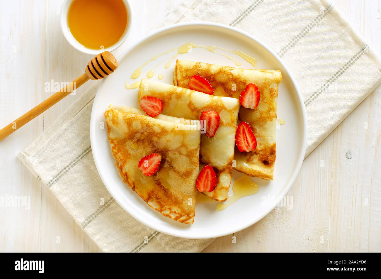 Des crêpes avec les tranches de fraises et le miel, délicieux petit-déjeuner. Vue de dessus, la télévision Banque D'Images