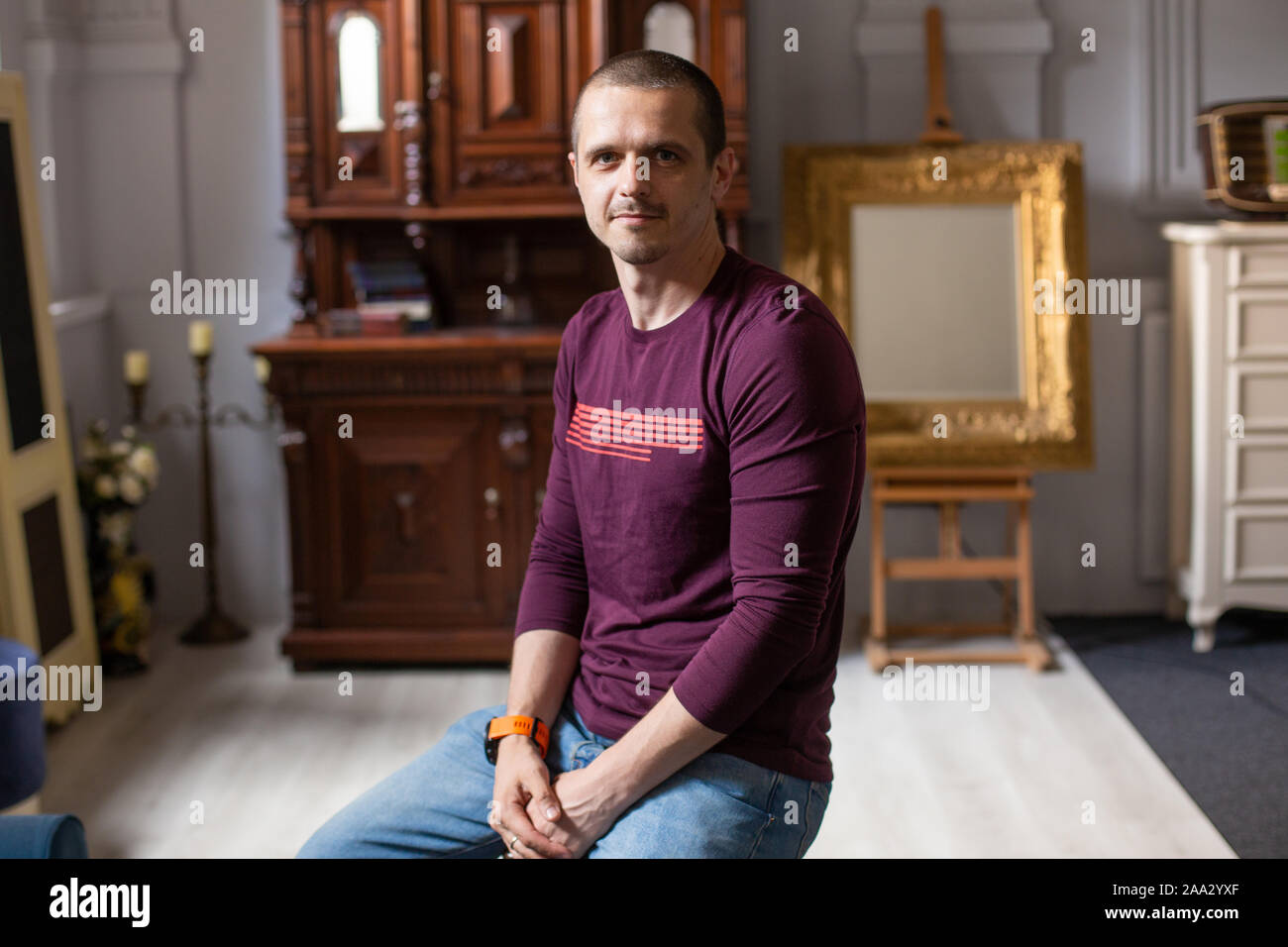 Dans l'homme sweatshot violet assis à la maison et à la caméra intégrée Banque D'Images
