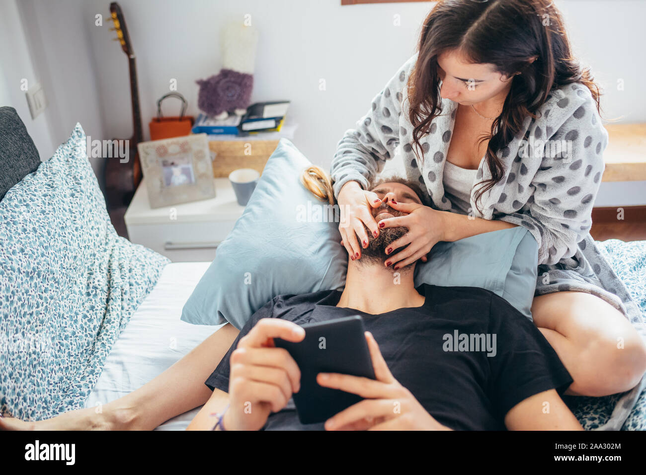 Belle jeune couple heureux en amour câlins bed using tablet - la vidéo en streaming, affectueux, technologie concept Banque D'Images