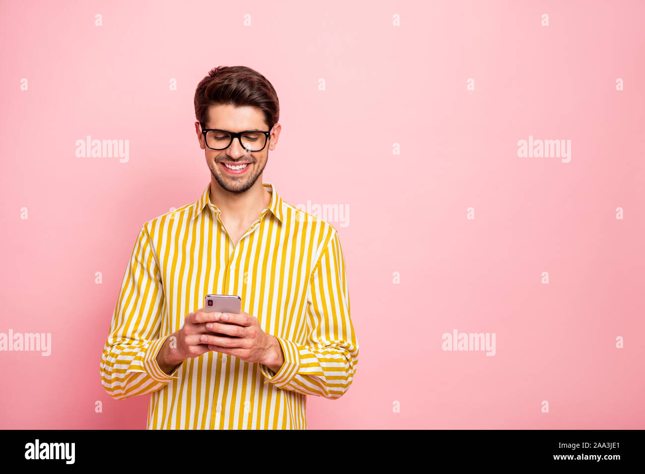 Photo de beau mec tapant copine téléphone sms holding toxicomanes social  personne porter des specs hipster rayée chemise rose isolé fond couleur  Photo Stock - Alamy