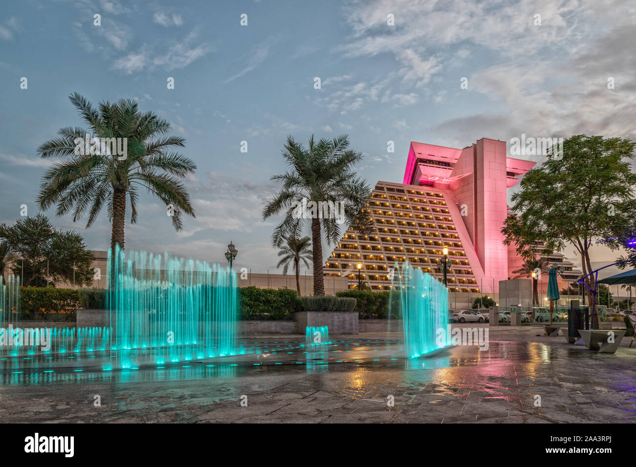 Vue extérieure de l'hôtel Sheraton Al Doha sur la lumière du jour avec fontaine éclairée en premier plan et nuages dans le ciel en arrière-plan Banque D'Images