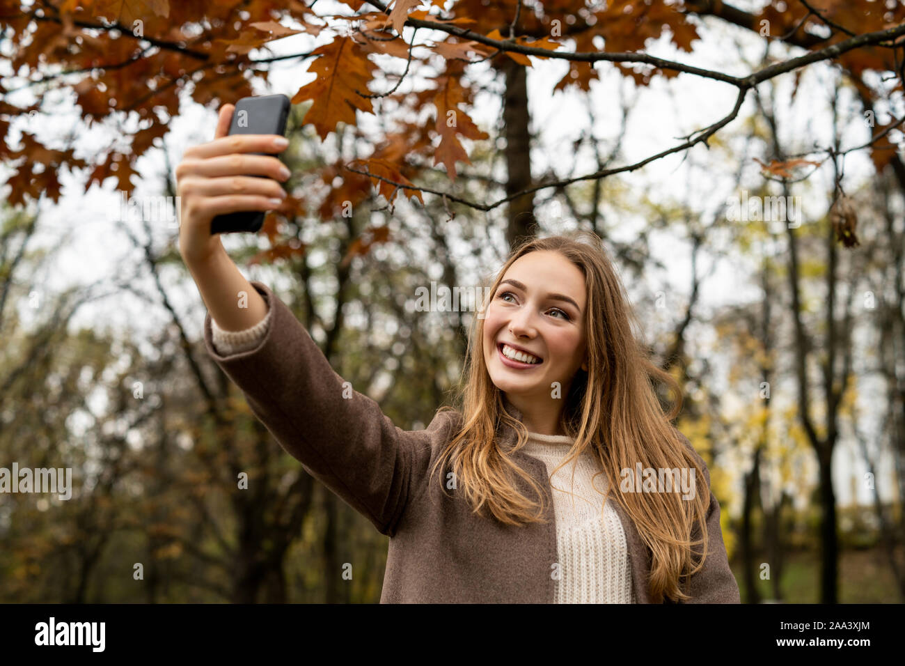 Smiling woman taking a dans le parc, selfies Belarus Banque D'Images