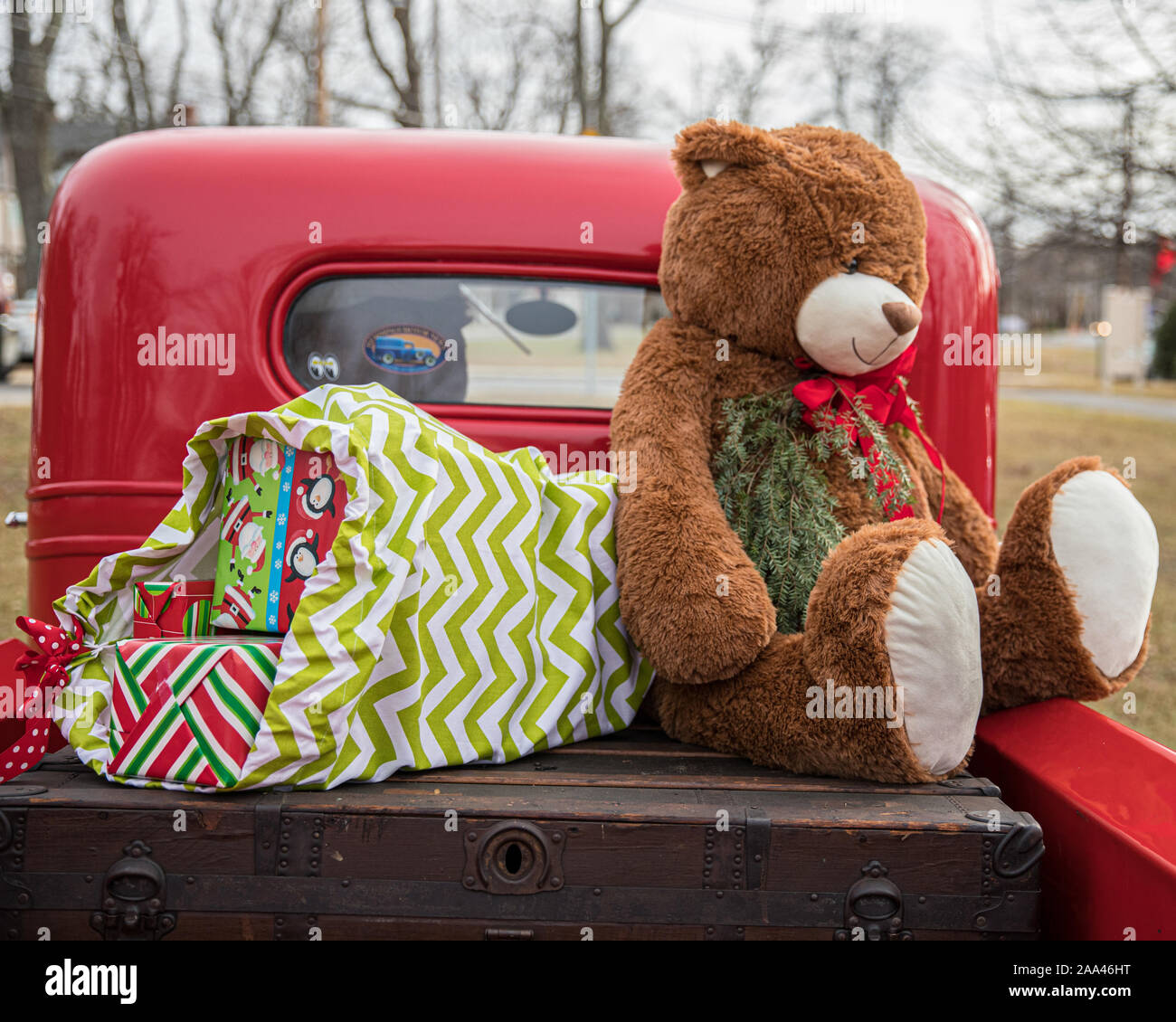 Un gros ours en peluche à l'arrière d'une vieille camionnette rouge Banque D'Images