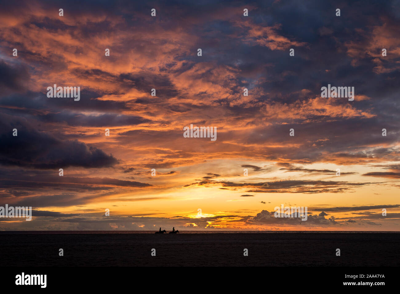 Silhouette de deux personnes de l'équitation sur la plage au coucher du soleil, Tarifa, Cadix, Andalousie, Espagne Banque D'Images