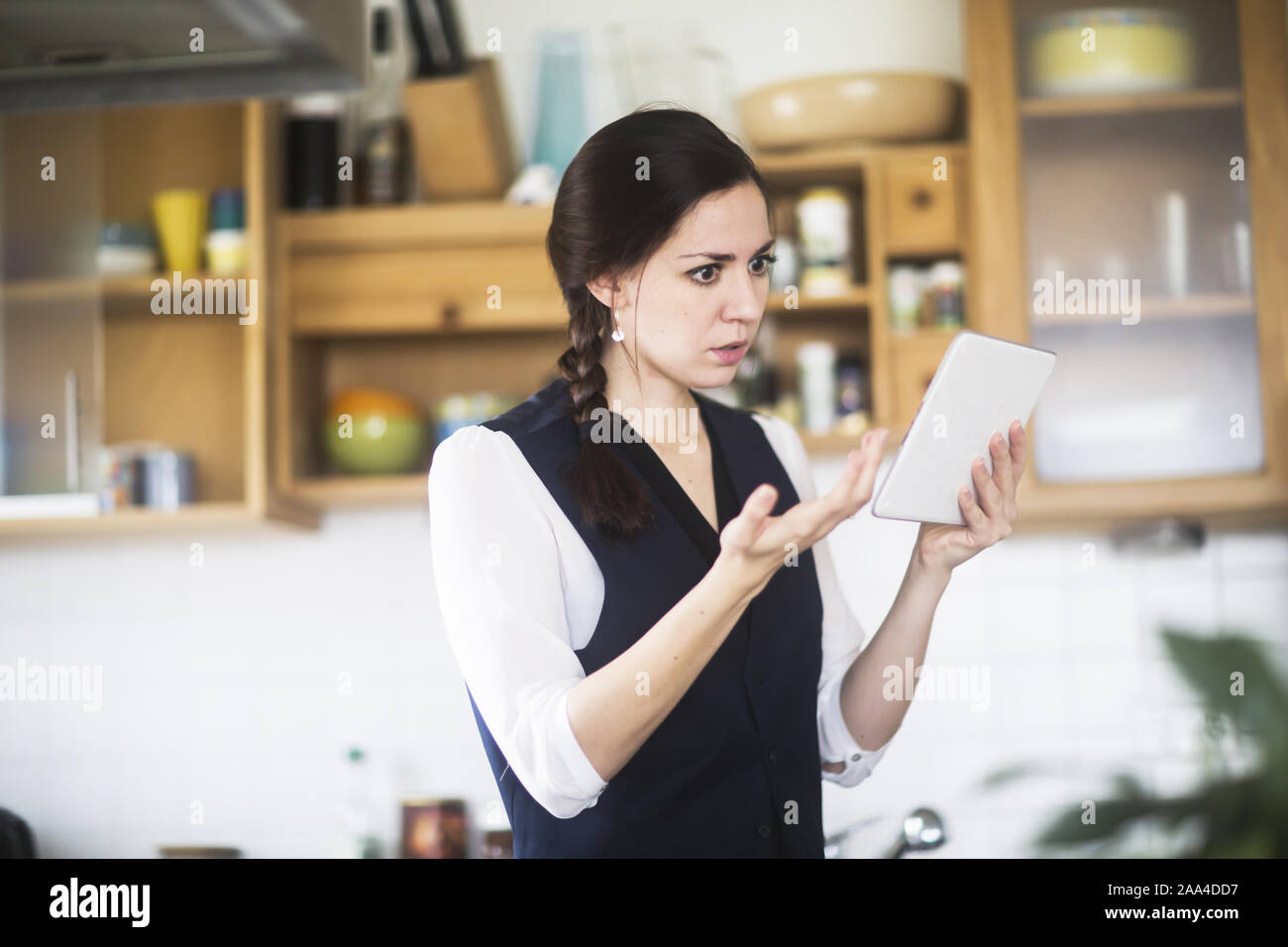 Femme debout dans la cuisine vidéo-conférence Banque D'Images