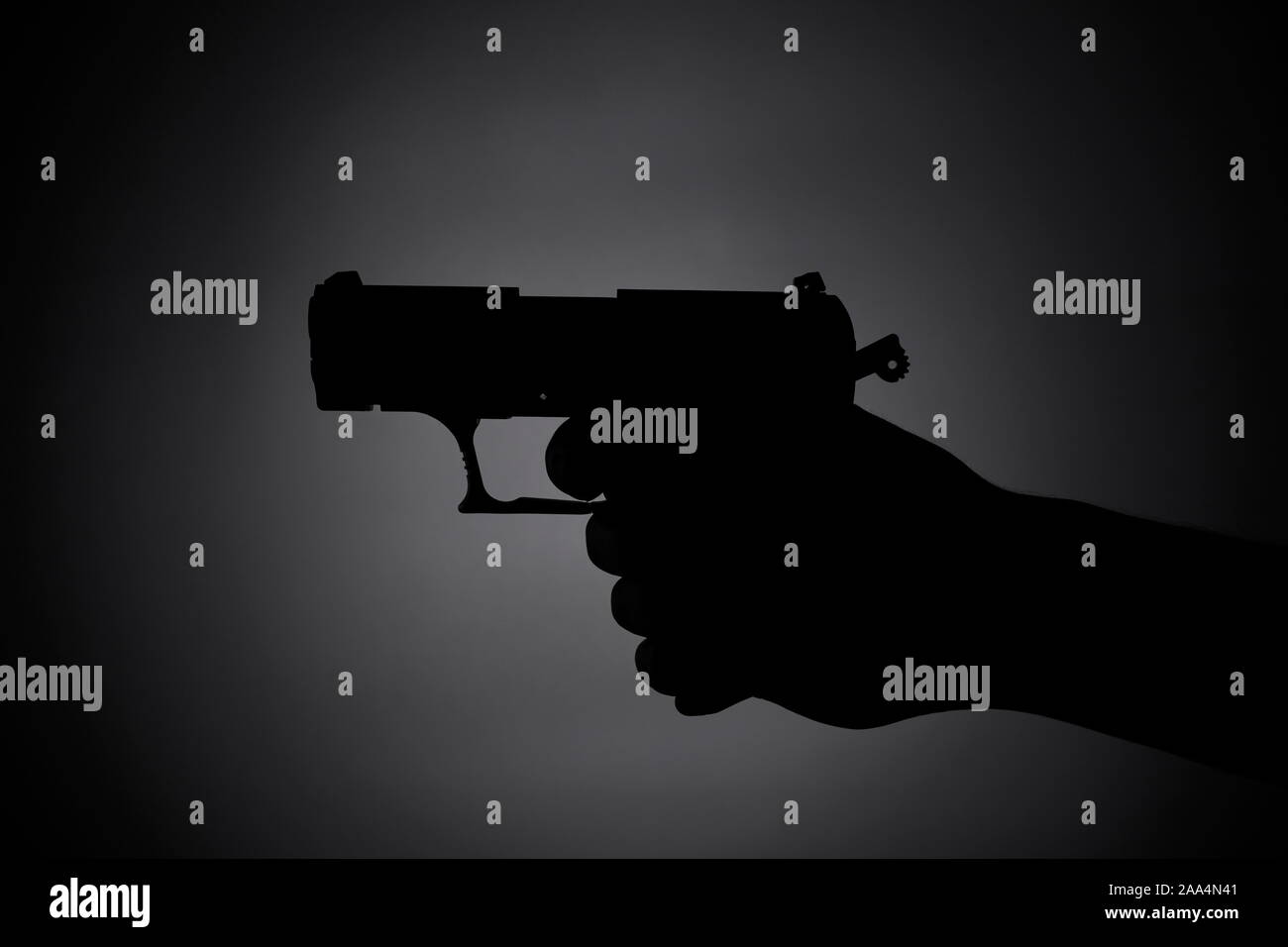 Attaquer avec une arme à feu dans l'obscurité de l'ombre - Banque D'Images